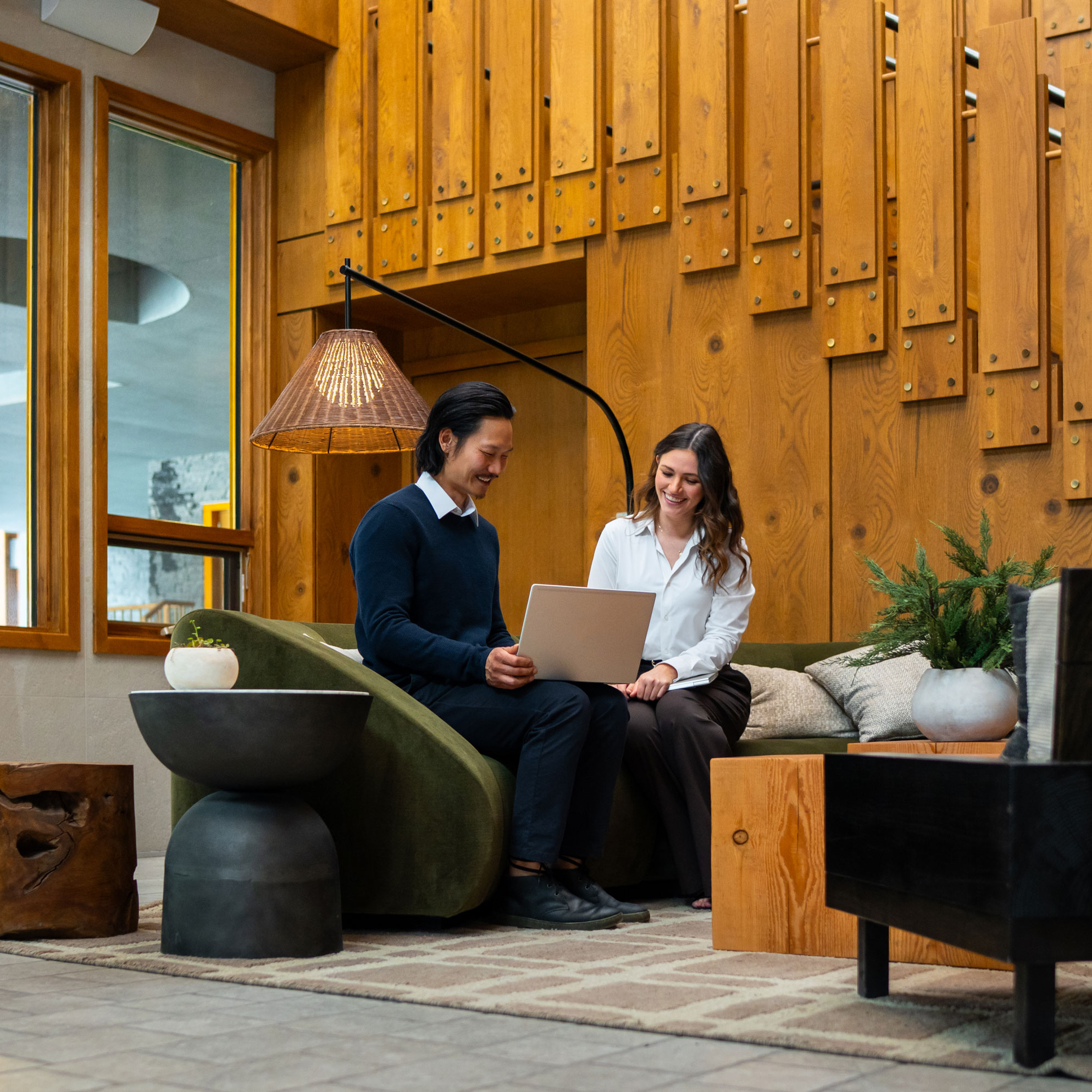 Couple sitting in otter hotel lobby banff using wifi